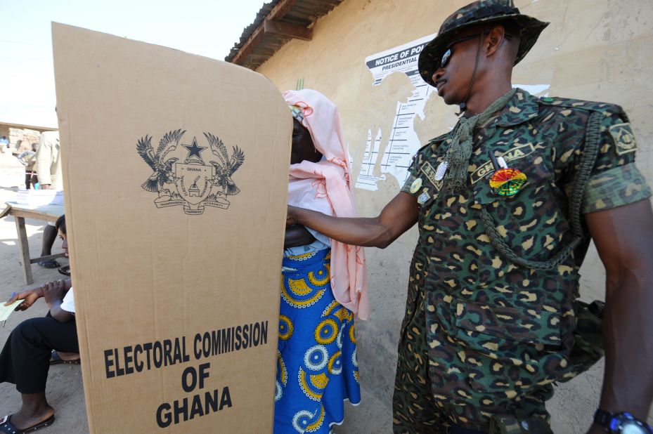 An immigration officer helps a voter at a polling station