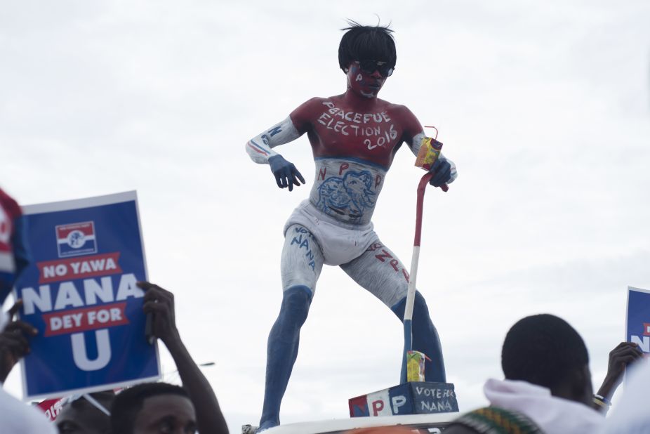 A supporter of Ghana's largest opposition party New Patriotic Party (NPP) dances ontop of a car in Accra on October 9, 2016