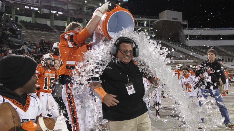 Calhoun City coach Perry Liles is doused with water after his team defeated Bay Springs 22-8 in a high school football championship game in Starkville, Mississippi, on Friday, December 2.