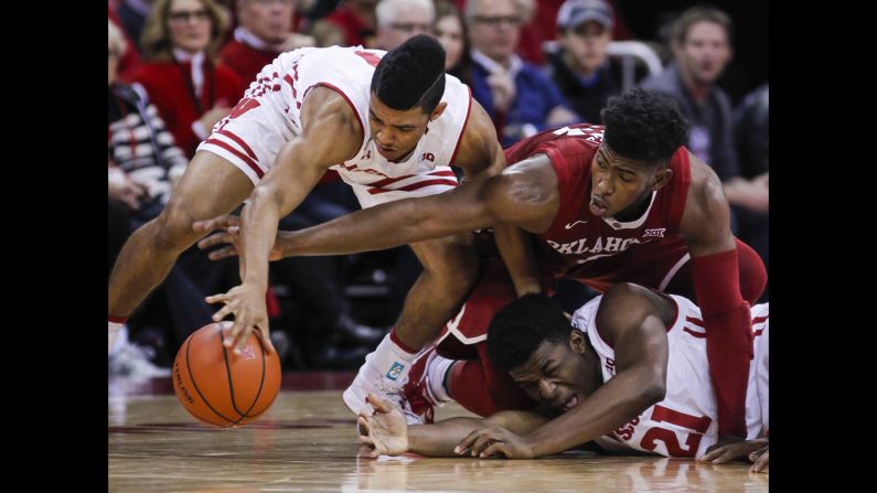 Wisconsin's D'Mitrik Trice, left, and teammate Khalil Iverson battle for a loose ball with Oklahoma's Christian James during the first half of an NCAA basketball game in Madison, Wisconsin, on Saturday, December 3. Wisconsin defeated Oklahoma 90-70.