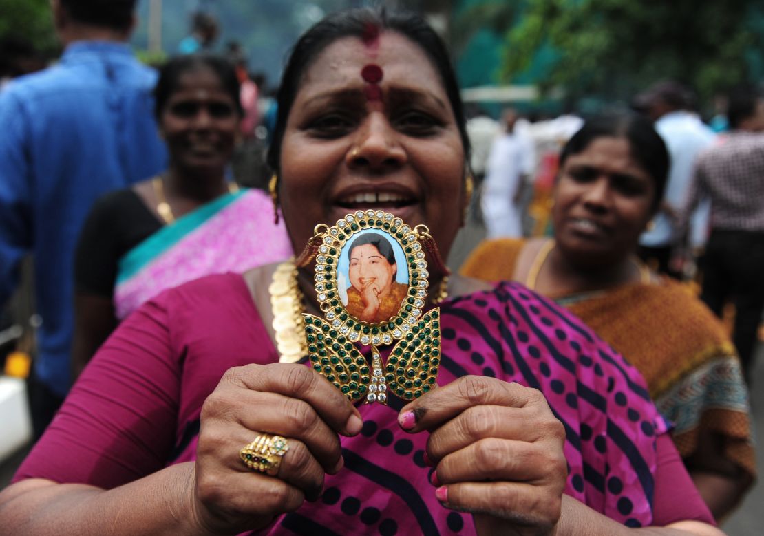 A woman displays a pendant with the image of  Jayalalithaa Jayaram as they celebrate election results in front of her residence in Chennai in May, 2016.