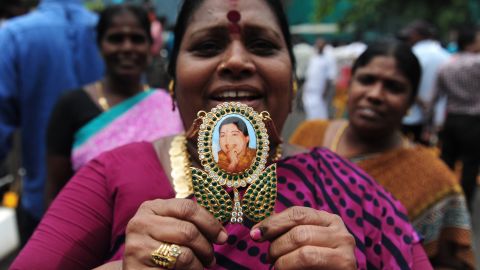 A woman displays a pendant with the image of  Jayalalithaa Jayaram as they celebrate election results in front of her residence in Chennai in May, 2016.