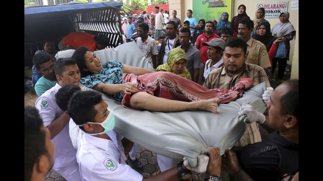 Medical personnel and family members transport a woman who was injured in the earthquake.