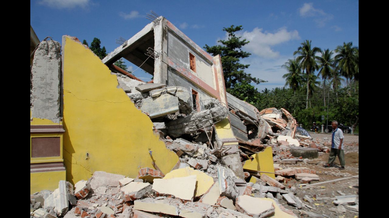 A man inspects a collapsed building in Pidie Jaya, Aceh province, on Indonesia's Sumatra island, Wednesday, December 7.