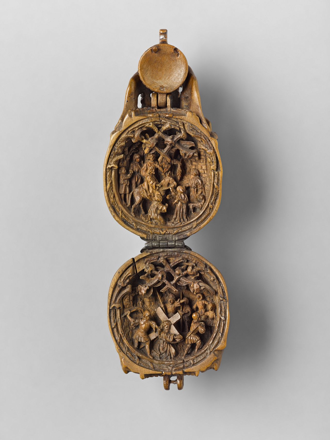 Inside one half of the skull-shaped prayer bead, Christ enters carrying the cross while being flogged 