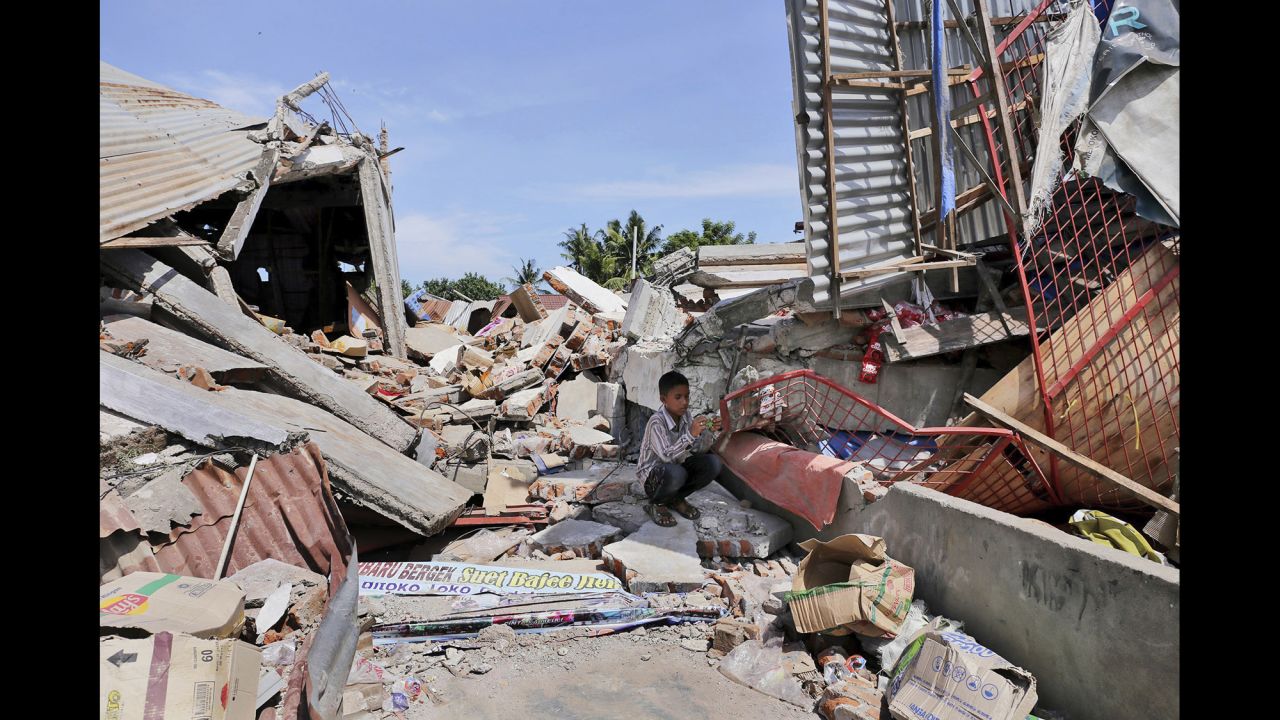 A boy takes shelter from the sun amid the rubble in Pidie Jaya.