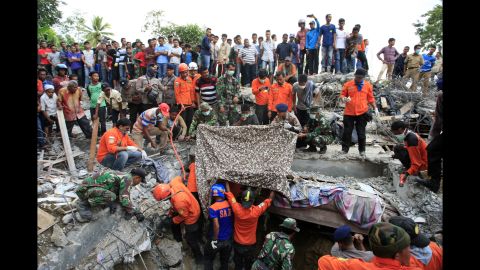 Rescuers, along with members of the Indonesian army, search debris for survivors in Lueng Putu town, Aceh province.