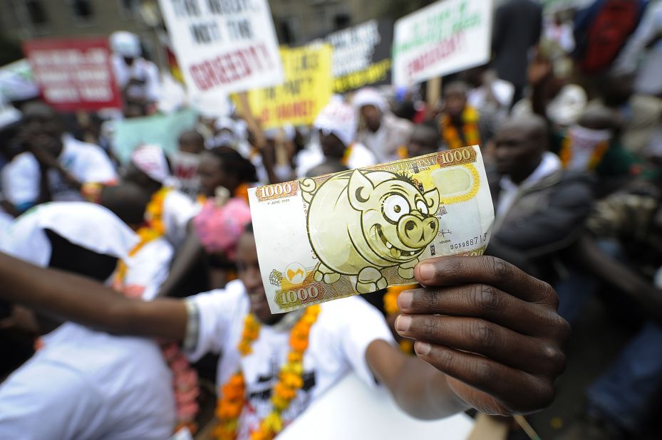 Just over half of Kenyan respondents say the national economy will improve in the next 12 months.<br /><br />Pictured here, protesters hold a fake bill imitation of local currency during a demonstration outside the parliament after lawmakers voted themselves hefty salary increases in June 2013 in Nairobi. 