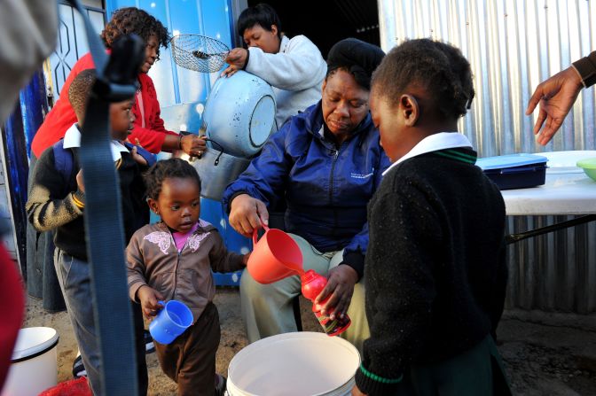 Health care is another issue just over 60% of South Africans believe will improve for their children.<br /><br />Pictured here: a mother gives out drinks to children who have lost parents to AIDS in Alexandra township in the north of Johannesburg in May 2012.