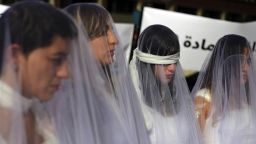 A dozen Lebanese women, dressed as brides in white wedding dresses stained with fake blood and bandaging their eyes, knees and hands stand in front of the government building in downtown Beirut, Lebanon, Tuesday, Dec. 6, 2016. The activists are protesting a Lebanese law that allows a rapist to get away with his crime if he marries the survivor. The law, in place since the late 1940s, is currently reviewed in Lebanese parliament. Campaigners against the law are calling on lawmakers to repeal the law during their meeting Wednesday. (AP Photo/Bilal Hussein)