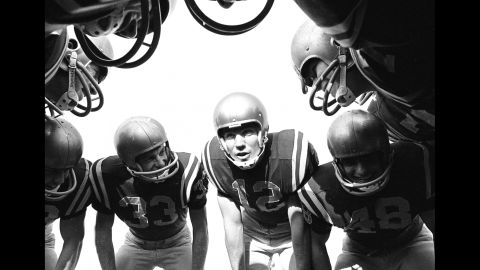 Navy quarterback Roger Staubach, No. 12, huddles with teammates during a game against the University of Pittsburgh on October 26, 1963. Staubach went on to play in four Super Bowls with the Dallas Cowboys.