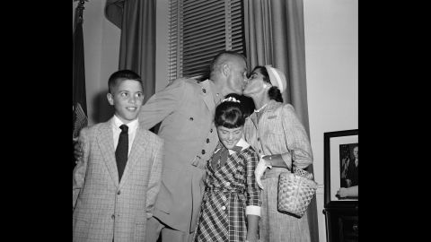 Glenn and his wife, Annie, sandwich their daughter, Carolyn "Lyn," as they embrace following a ceremony honoring his feat. Son David is at left.
