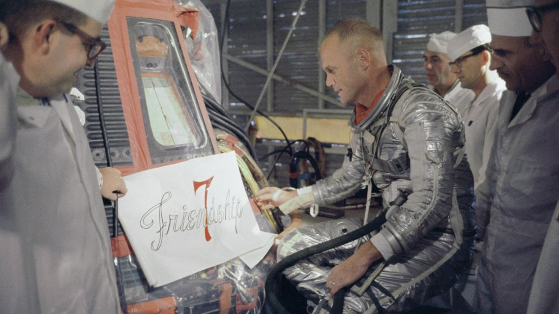 Glenn inspects artwork to be painted on the outside of his Mercury spacecraft, which he nicknamed Friendship 7. On February 20, 1962, Glenn  became the first American to orbit the Earth. After orbiting the Earth three times in four hours and 55 minutes, the Friendship 7 landed in the Atlantic Ocean.