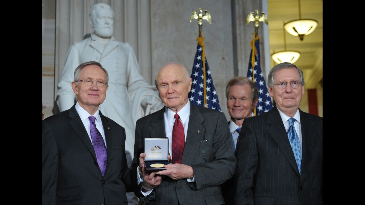 Glenn displays his Congressional Gold Medal with Sens. Harry Reid, left, Bill Nelson, second from right, and Mitch McConnell during a ceremony in the Capitol Rotunda in November 2011.