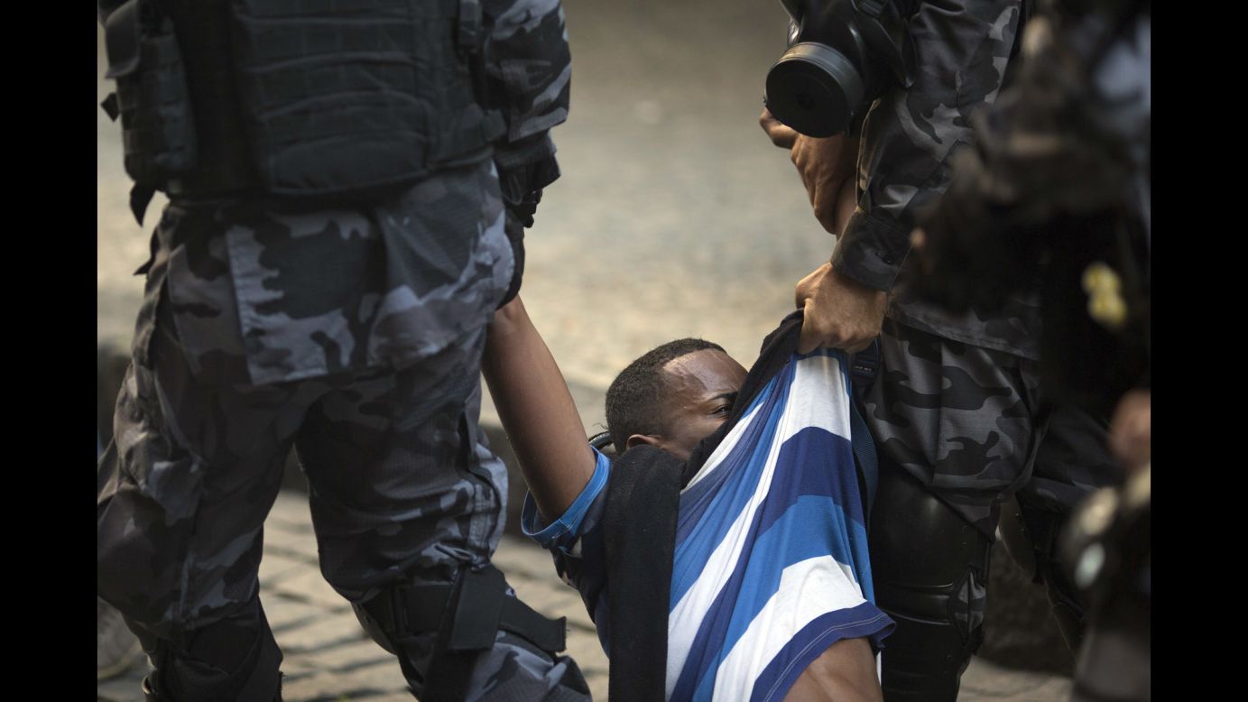 A demonstrator is arrested by police outside the state Legislature during a protest against newly proposed austerity measures in Rio de Janeiro on Tuesday, December 6. Hundreds of public sector workers have been protesting against possible spending cuts in the cash-strapped country.