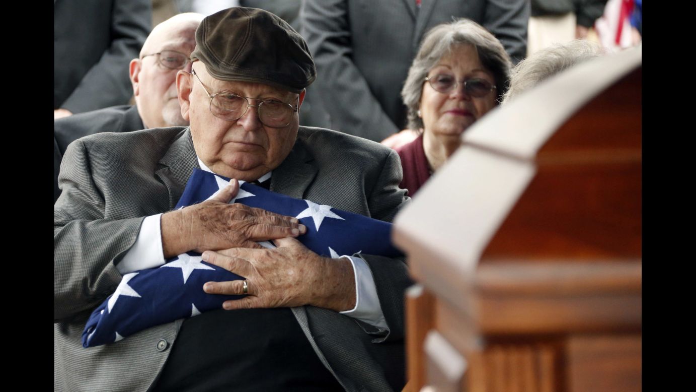 Frank Springs hugs the US flag that draped the casket of his uncle, Jim H. Johnston, a Navy Fireman 1st Class, who was buried with full military honors in Wesson, Mississippi, on Wednesday, December 7. 