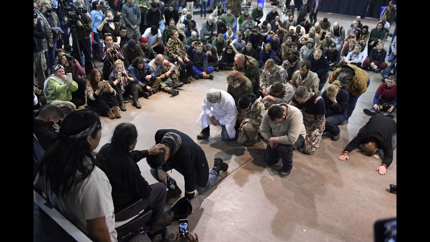 Wesley Clark Jr. kneels in front of Leonard Crow Dog during a forgiveness ceremony at the Standing Rock Sioux Reservation in Fort Yates, North Dakota, on Monday, December 5. A group of US veterans asked Native Americans to forgive the military actions carried out against the Native American people throughout history.