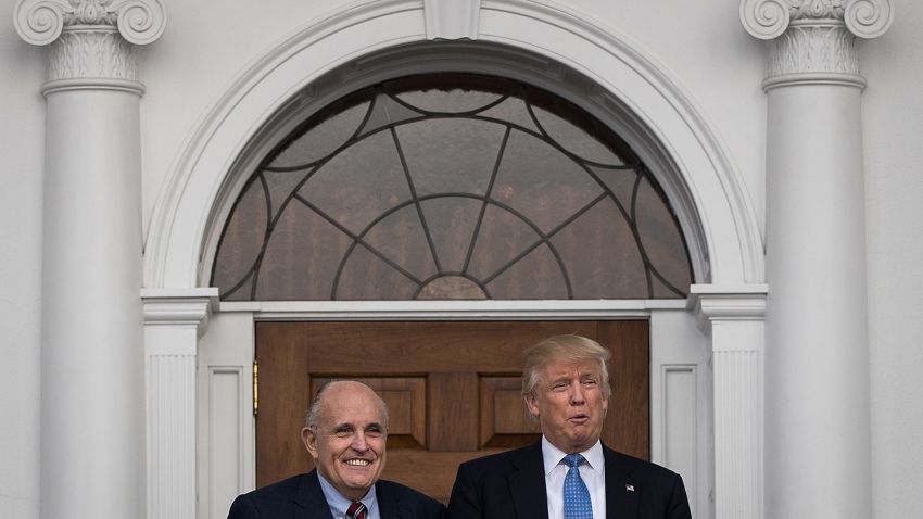Former New York City mayor Rudy Giuliani stands with president-elect Donald Trump before their meeting at Trump International Golf Club on November 20, 2016, in Bedminster Township, New Jersey.