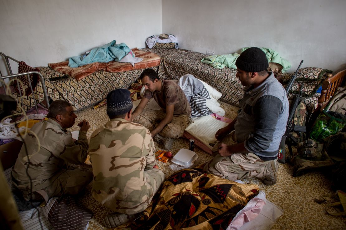 Iraqi soldiers eat in a house  in the Entisar neighborhood of Mosul last month.  