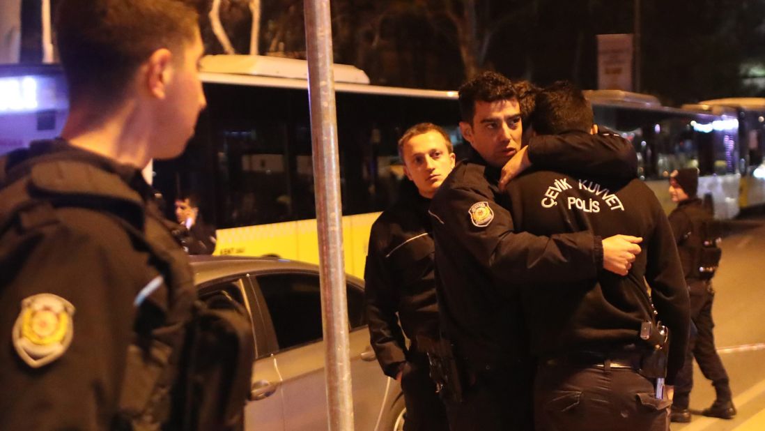 Police officers hug each other after an explosion near the stadium. 