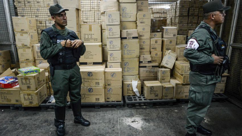 Members of the Venezuelan national guard stand next to boxes full of confiscated toys in a warehouse in Caracas on December 9, 2016. The Venezuelan government seized 3.8 million toys on December 9, 2016 from one of the country's main distributors - which it accuses of hoarding - to sell them at lower prices in poor neighborhoods.