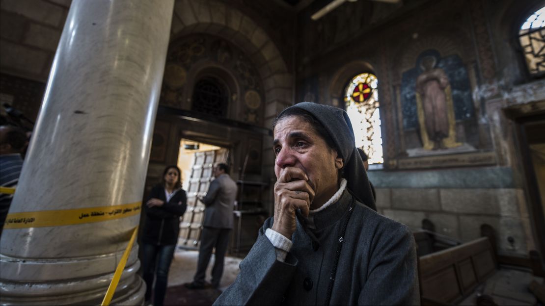 A nun reacts as Egyptian security forces inspect the scene of the bomb explosion.