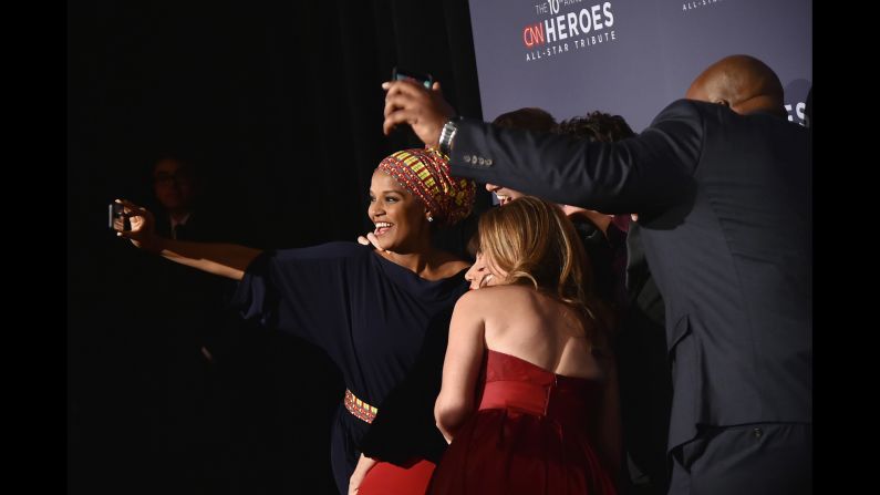 Umra Omar, left, takes a selfie with her fellow Top 10 CNN Heroes on the red carpet as they get ready for the awards show.