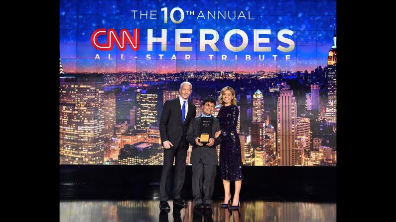 2016 CNN Hero of the Year Jeison Aristizábal poses on stage with hosts Anderson Cooper and Kelly Ripa.