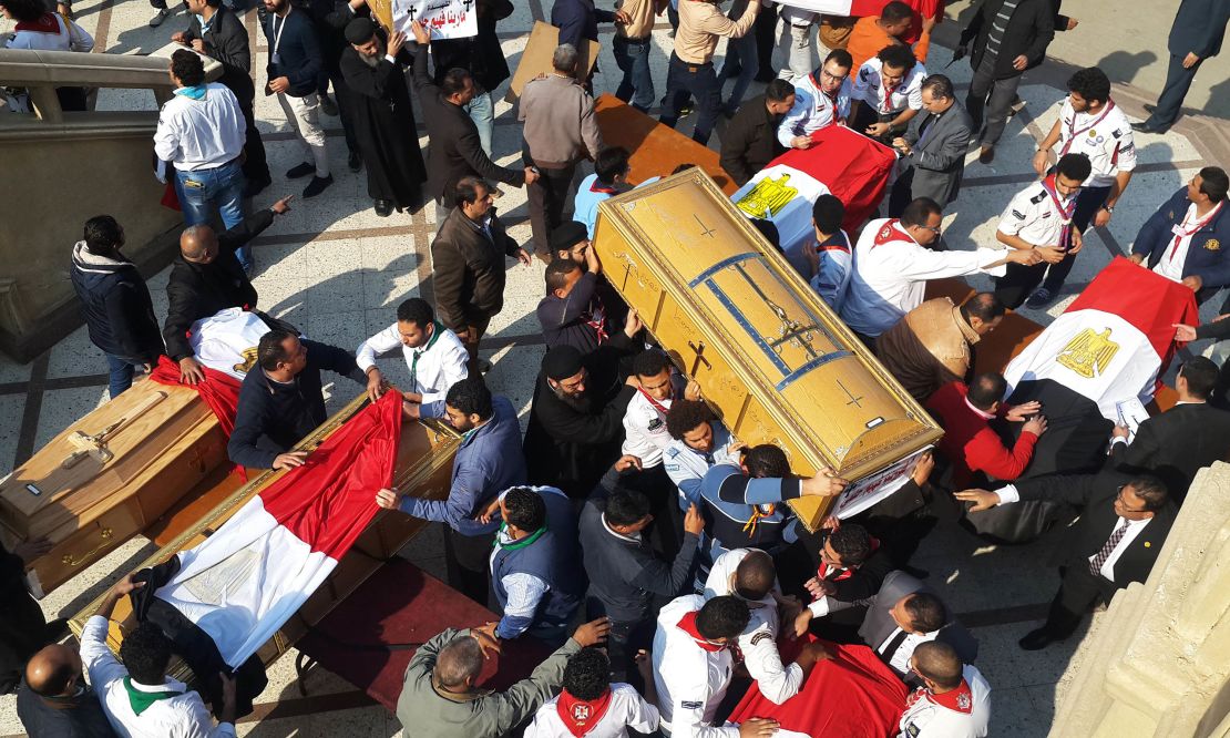 Egyptian clergymen and officials carry the coffins of the victims of the bomb explosion. 
