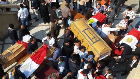 Egyptian clergymen and officials carry the coffins of the victims of the bomb explosion.