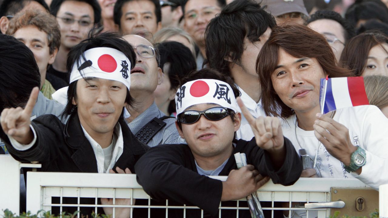Paris, FRANCE: Japanese support the horse, Deep Impact and his jockey Yutake Take of Japan which attract a huge fan club, during the Prix de l'Arc de Triomphe's race at Longchamp, 01 October 2006 in Paris. Around 5,000 Japanese nationals had travelled over to Longchamp, in western Paris to see the five-year-old colt take on Europe's finest including last year's champion Hurricane Run but that did not deter them from queuing up at a specially designated betting stall solely for Japanese punters. AFP PHOTO BERTRAND GUAY (Photo credit should read BERTRAND GUAY/AFP/Getty Images)
