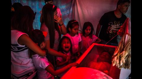 <strong>October 9: </strong>Jimji, 6, cries out "Papa" as workers move the body of her father, Jimboy Bolasa, for burial in Manila, Philippines. Bolasa, 25, was found dead along with his neighbor. New Philippines President Rodrigo Duterte campaigned hard on <a href="http://www.cnn.com/2016/08/03/asia/philippines-war-on-drugs/" target="_blank">a no-nonsense approach to crime,</a> and on several occasions he has hinted openly that he doesn't oppose his police force or even citizens taking the lives of suspected criminals. Critics see the approach as a complete disregard of due process. "It's absolutely crippling to see that image and to see that little girl experiencing so much pain and loss; to know that her father was never given a trial, never had the opportunity to defend himself in front of a court," <a href="http://time.com/top-10-photos-2016/" target="_blank" target="_blank">Daniel Berehulak said</a> about the photo, which he took<a href="http://www.nytimes.com/interactive/2016/12/07/world/asia/rodrigo-duterte-philippines-drugs-killings.html" target="_blank" target="_blank"> on assignment for The New York Times.</a> "He was tortured and executed in the space of 30-45 minutes." <a href="http://www.cnn.com/2016/08/28/asia/philippines-voices-drugs-war/index.html" target="_blank">Duterte's crackdown: 6 stories from the front lines</a>
