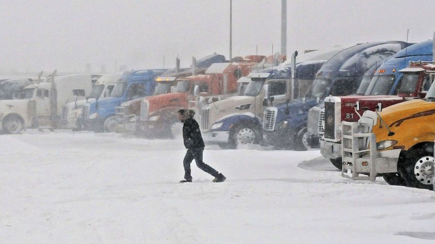 Alf Carlson, a storm stranded driver from Winnipeg, Manitoba, Canada, walks from his truck to the Stamart Truck Stop in Bismarck, N.D., before dawn on Tuesday, Dec. 6, 2016.. Carlson said he spent the night in his truck waiting out a winter blizzard that forced closure of Interstate 94. "I'm trying to get to Lame Deer, Montana," said Carlson who said he had no choice but wait out the blizzard that forced closures throughout North Dakota. The National Weather Service issued a blizzard warning for much of western and central North Dakota through Tuesday afternoon. (Tom Stromme/The Bismarck Tribune via AP)