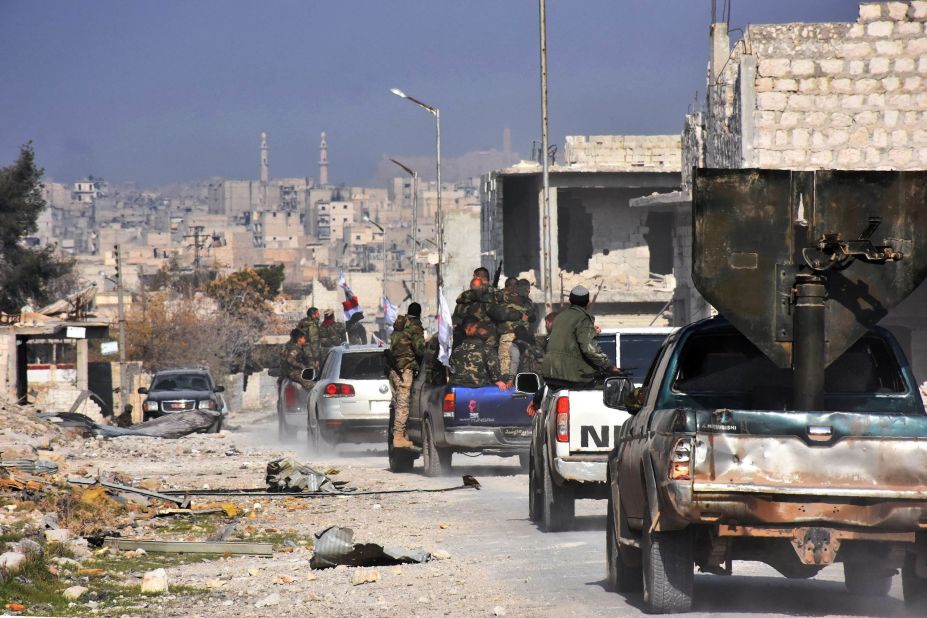 Pro-government forces patrol Aleppo's Sheikh Saeed district on December 12 after it was recaptured from rebel forces.