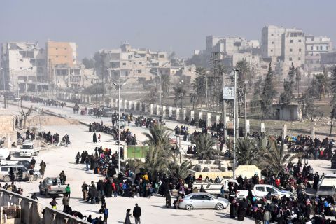 Civilians from eastern Aleppo stream into a government checkpoint at the al-Hawoz street roundabout on Saturday, December 10.