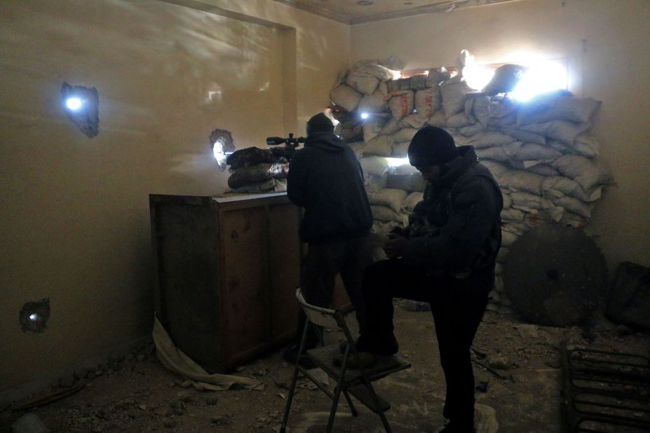 Rebel fighters take aim at pro-government positions in Aleppo on Friday, December 9.