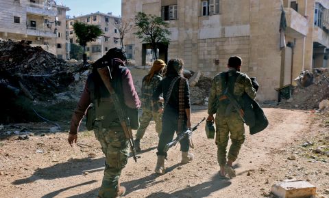 Syrian rebels walk down a street in eastern Aleppo on December 9.