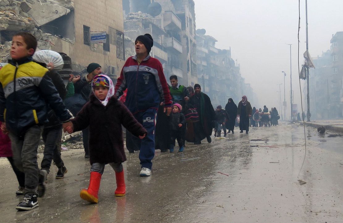 Syrian children flee with their families from the Bustan al-Qasr neighborhood in Aleppo on Tuesday.