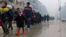 Syrian residents, fleeing violence in the restive Bustan al-Qasr neighbourhood, arrive in Aleppo's Fardos neighbourhood on December 13, 2016, after regime troops retook the area from rebel fighters. 
Syrian rebels withdrew from six more neighbourhoods in their one-time bastion of east Aleppo in the face of advancing government troops, the Syrian Observatory for Human Rights said. / AFP / STRINGER        (Photo credit should read STRINGER/AFP/Getty Images)