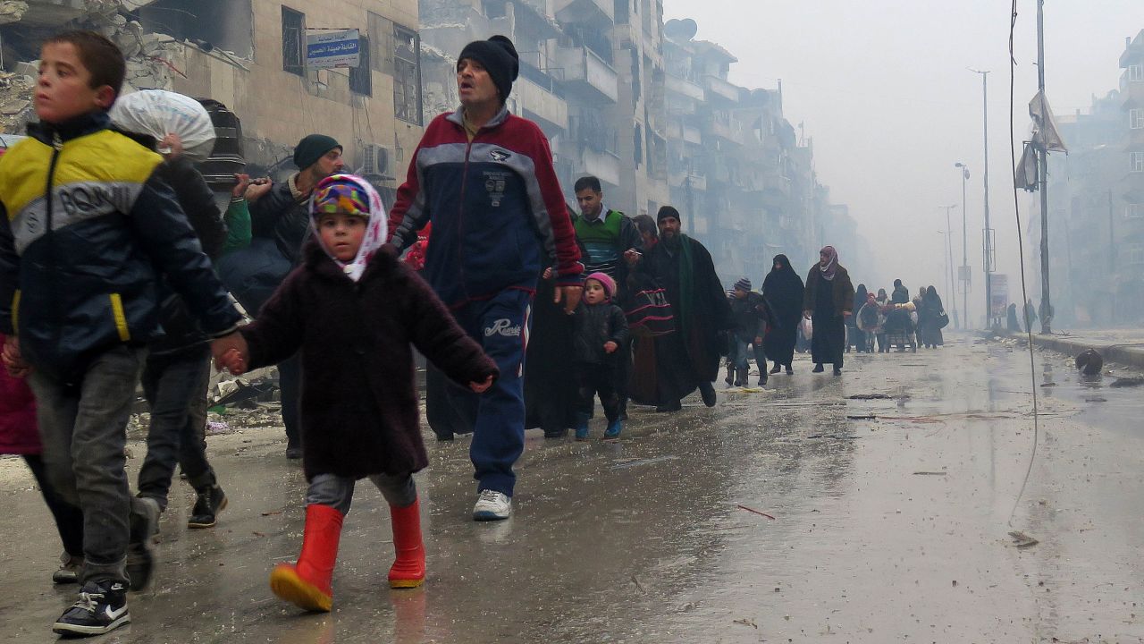 Syrian children flee with their families from the Bustan al-Qasr neighborhood in Aleppo on Tuesday.