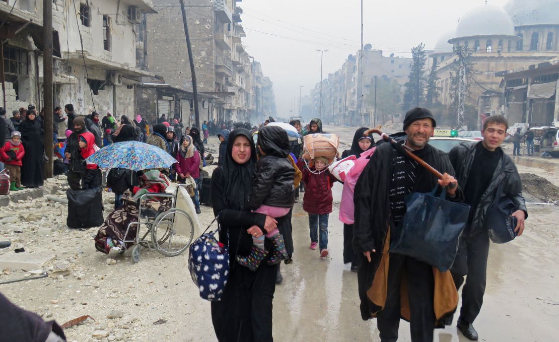 Syrians fleeing the restive Bustan al-Qasr neighbourhood on Tuesday.