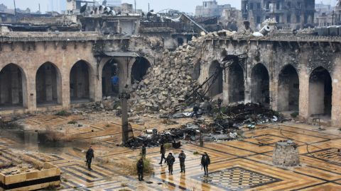 Pro-government forces walk in the ancient Umayyad Mosque after capturing the area on Tuesday, December 13.
