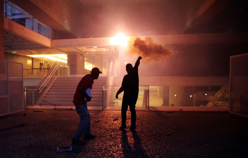 Protesters throw a flare towards the Sao Paulo Industry Federation building in Sao Paolo, Brazil, on Wednesday, December 14. Protests erupted across 15 cities in Brazil as lawmakers voted to pass constitutional amendment PEC 55, which will limit public spending over a 20 year period.