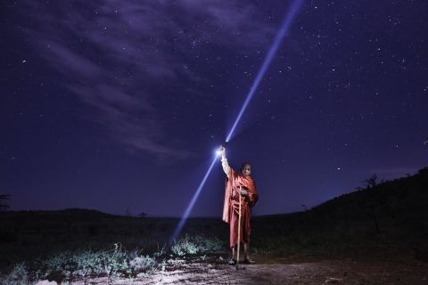 A young Maasai boy brings a solar torch to the field to check on his cattle at night. The torch is part of a program run by Off Grid Electric, a company which aims to bring affordable energy to sub-Saharan Africa.