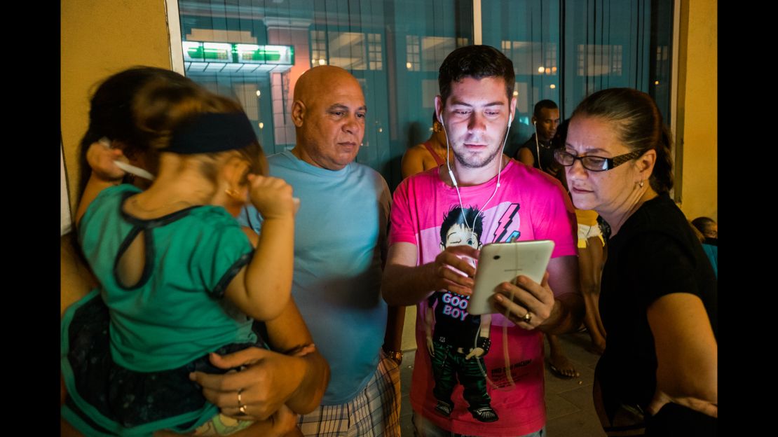 Raul Rossell, center, stands with son Aniel and other family members outside a Havana hotel.