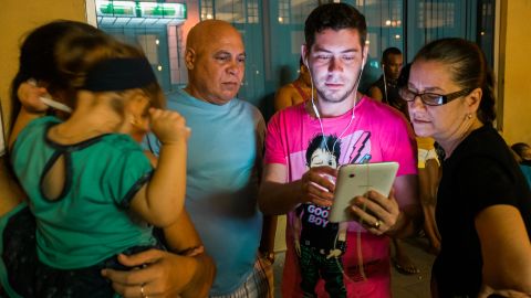 Raul Rossell, center, stands with son Aniel and other family members outside a Havana hotel.  