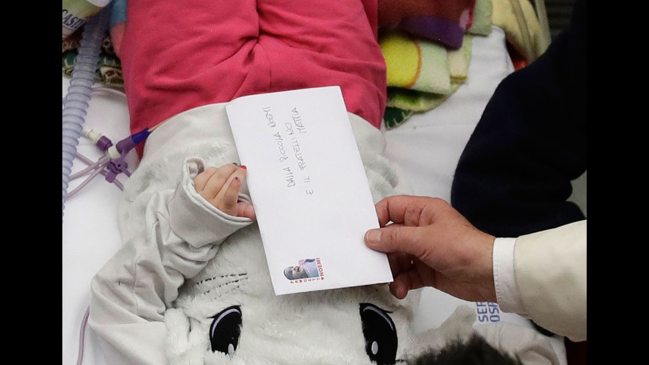 Pope Francis accepts a letter from a child he visited at a pediatric hospital in Rome on Thursday, December 15, 2016.