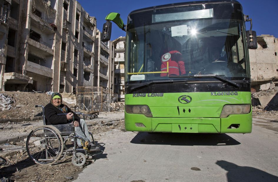 A woman in a wheelchair waits to board a bus during evacuations on December 15.