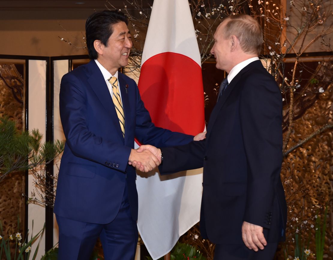 Abe, left, shakes hands with Putin prior to their talks in Nagato on December 15.