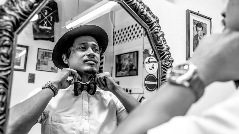 Elyas, the head barber and owner of Son & Dad Barbers in George Town, Penang, Malaysia, straightens his collar in this image by UK photographer, Alison Cahill, the winner of the New Talent -- Eye to Eye category.